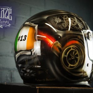 Black motorcycle helmet with airbrushed steampunk skull design featuring golden mechanical gears, orange turbo charger, and Irish flag